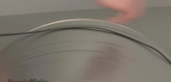 Slide the belt over the drum rib side down and replace the drum, looping the belt around the idler and motor pulleys.