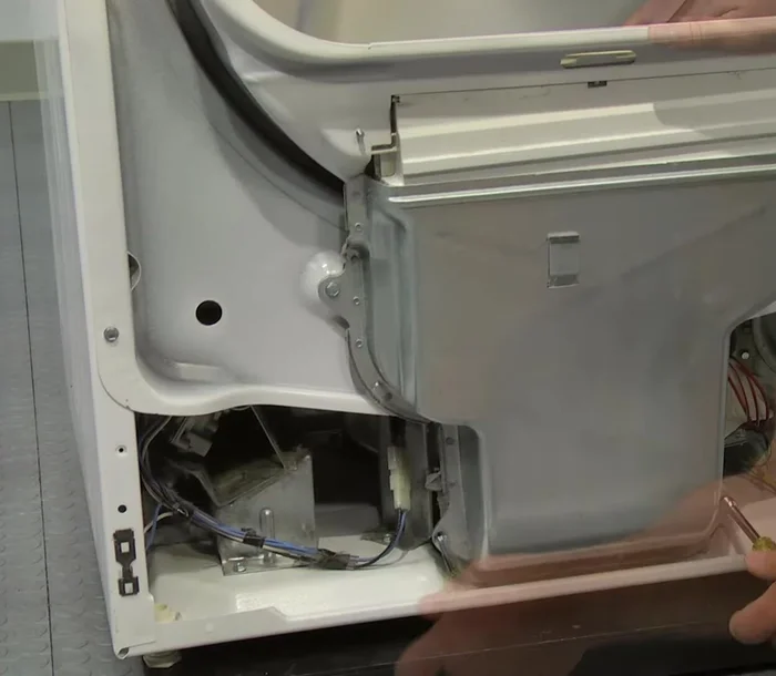 Remove the front bulkhead by removing two screws at the bottom and two on each side, then loosening two at the top.