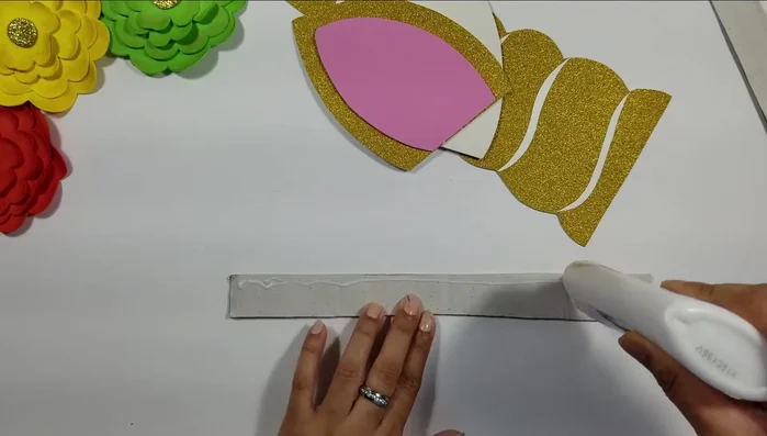 Glue the flowers to a thick cardboard piece to create the unicorn head.