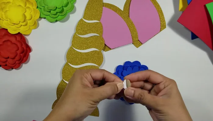 Glue golden glitter paper to the center of each flower.