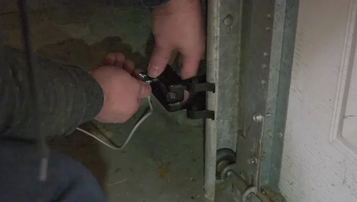 Attach the garage door sensors to their brackets using the provided bolts and wing nuts.