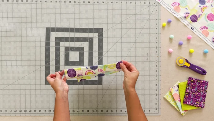 Attach pocket 6 (water bottle pocket): Insert elastic, fold, pleat, and stitch.