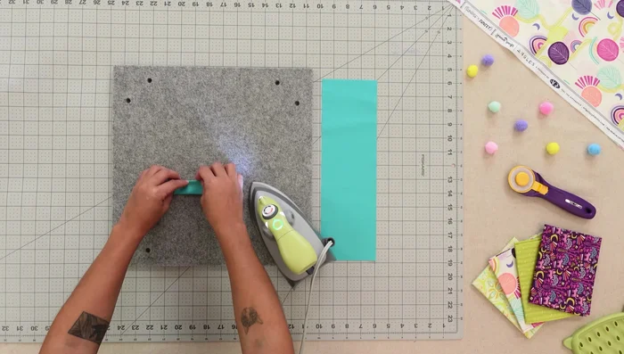 Prepare and attach sunglass pocket and top strap: Fold, press, and stitch.