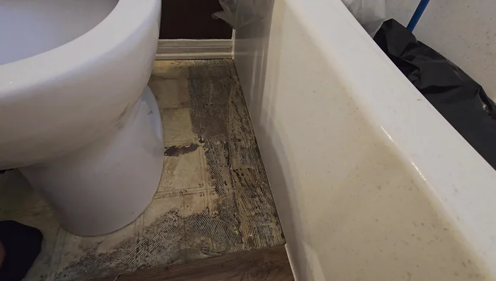 Clean and apply silicone caulk around the toilet base for a watertight seal.