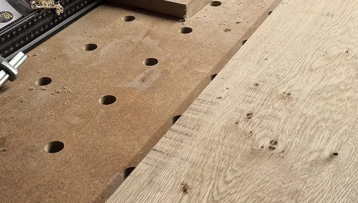 Cut the larger drink holder hole: Drill a center hole for stability, then use the router or bandsaw for larger cuts.