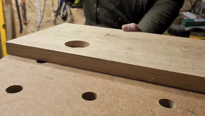 Cut the larger drink holder hole: Drill a center hole for stability, then use the router or bandsaw for larger cuts.