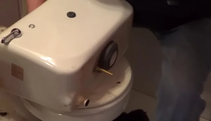 Replace the tank onto the bowl and secure it from underneath, ensuring even tightening of nuts with a helper.