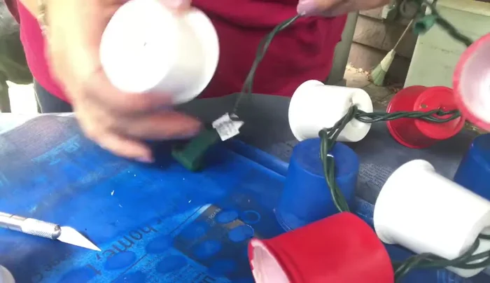 Insert mini Christmas lights through the holes in the K-cups, arranging them in your desired color pattern.