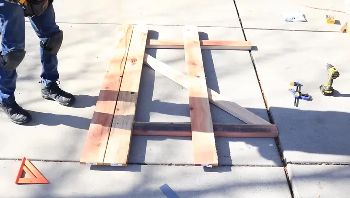 Attach two fence pickets to the hinge side rails, using the pre-measured distance from the fence top to bottom rail center for placement.