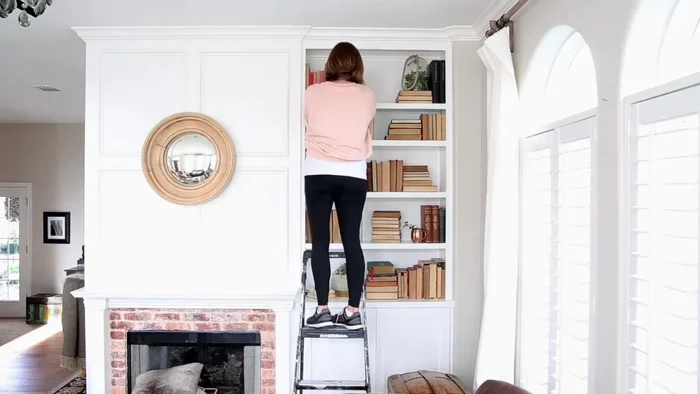 Clear and plan: Remove all decorative items and books from the bookcase. Consider the desired color scheme and overall style for the spring season (e.g., lighter colors, blues and greens).