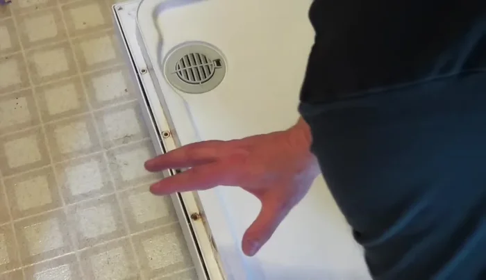 Separate the front and back parts of the dishwasher door. Locate the broken latch.