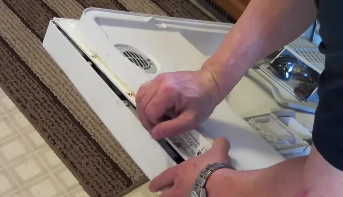 Reassemble the dishwasher door, securing it with the screws.