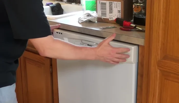 Open the dishwasher door. If the latch is broken and the door won't open, firmly grab both sides of the door and pull it out.