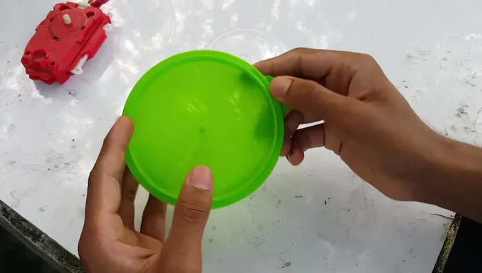 Prepare the plastic container. Make a small hole in the center of the container cap.