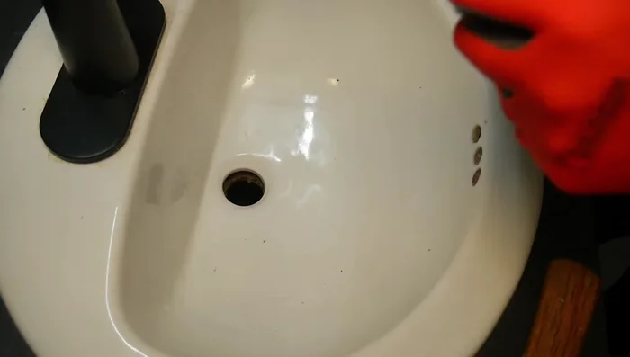 Prepare the new drain assembly. Apply Teflon tape to metal-to-metal connections if needed. (Note: The video uses silicon gaskets, suggesting plumber's putty may not be strictly necessary).