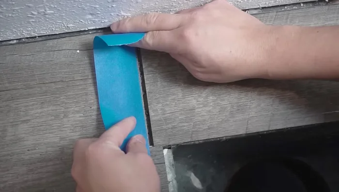 Apply masking tape along the edges of the damaged area to protect surrounding planks.