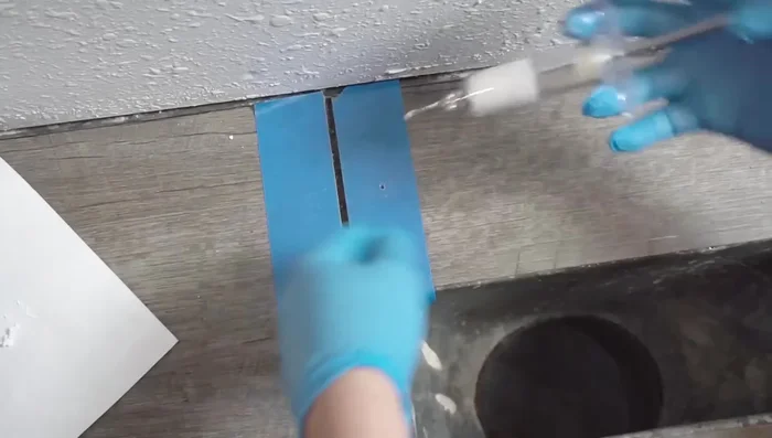 Drill a hole in the damaged area and fill it with caulk using a syringe. If using the syringe and flexible tube, ensure the syringe is stable to prevent caulk spillage.