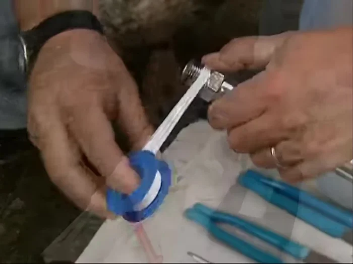 Connect the PEX tubing to the outdoor sillcock using Teflon tape, a transition fitting, and two wrenches to ensure a watertight connection.