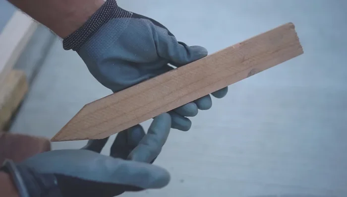 Attach redwood stakes: Attach redwood stakes to the bottom of the frame using screws.