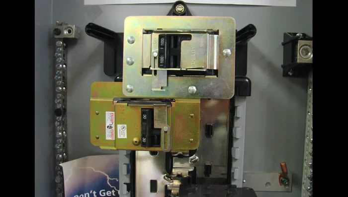 Identify and acquire a suitable interlock device for your specific electrical panel. Gather information (brand name, model number) from your panel to cross-reference with available interlock devices at a supply house.