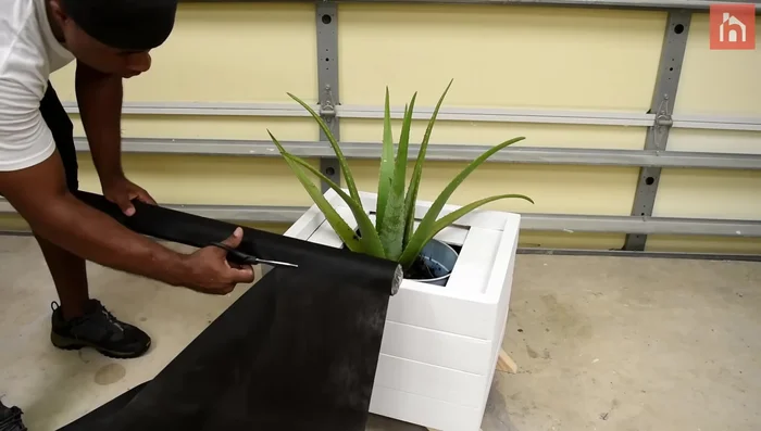 Insert the flower pot, add weed barrier and rocks.