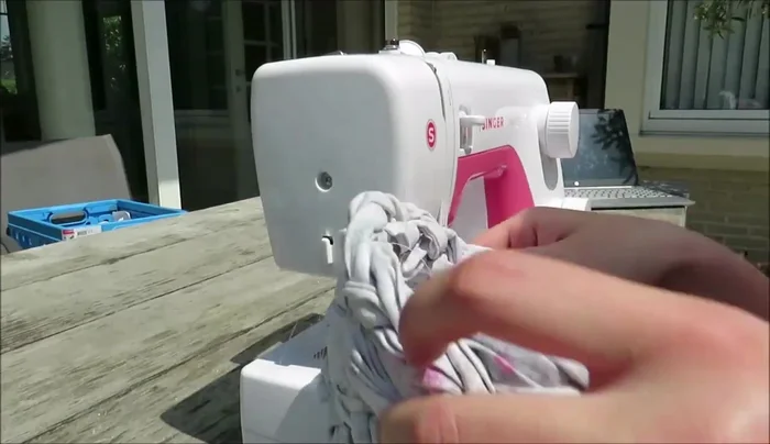 Cut the remaining braid short and zigzag stitch the edges for a neat finish. Then sew it to the inside of the basket, underneath the strap for the lid.