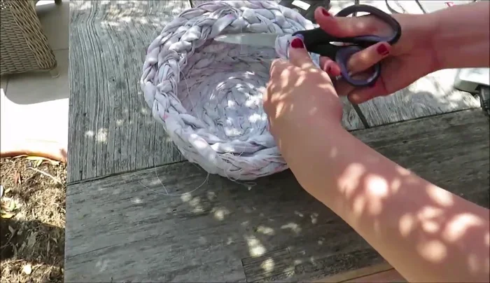 Cut the remaining braid short and zigzag stitch the edges for a neat finish. Then sew it to the inside of the basket, underneath the strap for the lid.