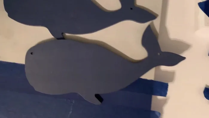 Creating a rustic look on a Target dollar spot wooden board using a ruler, pencil, and finger to rough up the paint.