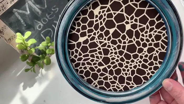 Adding Dollar Tree nautical rope twine to create a hanger for a DIY decor piece.