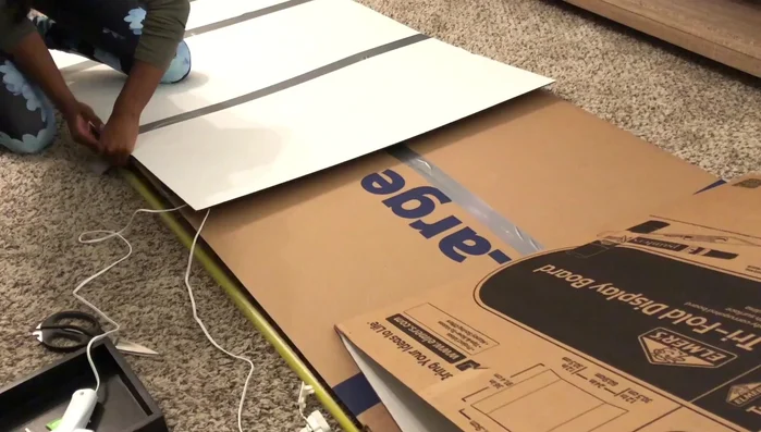 Reinforce the base: Attach trifold poster boards to the top of the taped boxes for added stability.