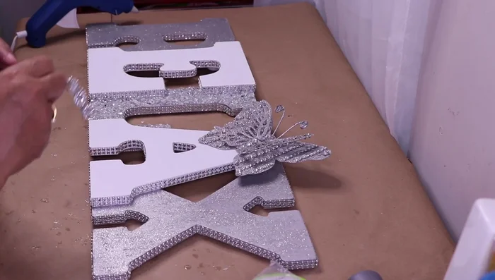 Glue the butterfly to the letter 'A', adding flower bling and rhinestones.