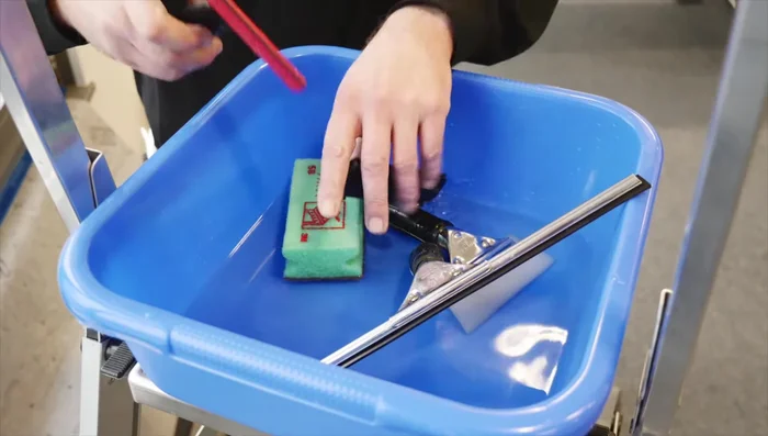 Clean the window thoroughly using water, mild detergent, and a stainless steel scraper. Remove excess water with a squeegee.