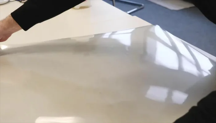 Wet the film with a solution of water and mild detergent, then roll it up tightly.