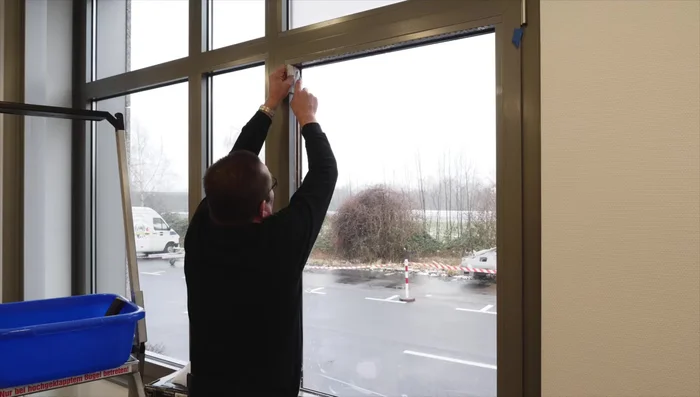 Cut excess film along the edges of the frame with a knife and plastic squeegee.