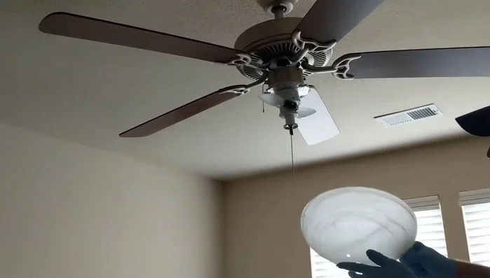 Reattach the fan chain, feeding it back up through the globe and hooking it to the coupling.