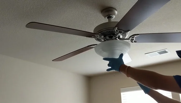 Reattach the fan chain, feeding it back up through the globe and hooking it to the coupling.