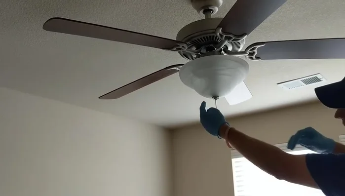 Reattach the fan chain, feeding it back up through the globe and hooking it to the coupling.