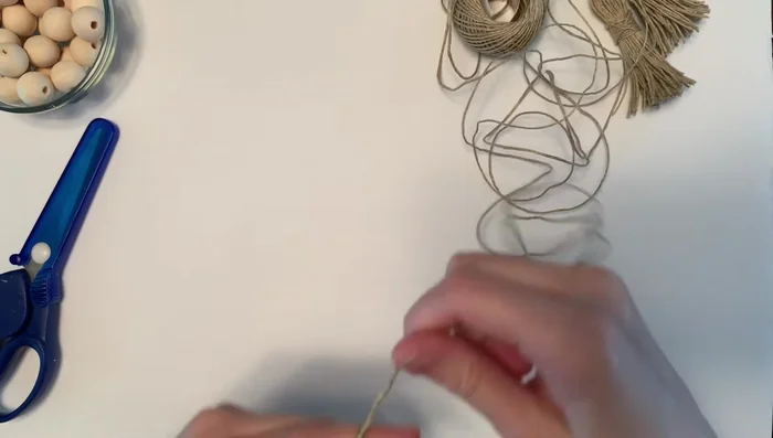 Secure tassel head: Cut another piece of twine, wrap it tightly around the tassel head, double knot, and trim the ends.