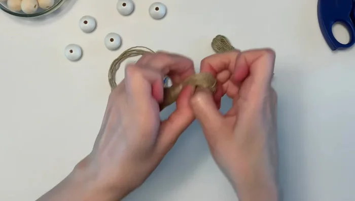 Attach tassel to twine: Insert the twine through the tassel head and double knot to secure it.