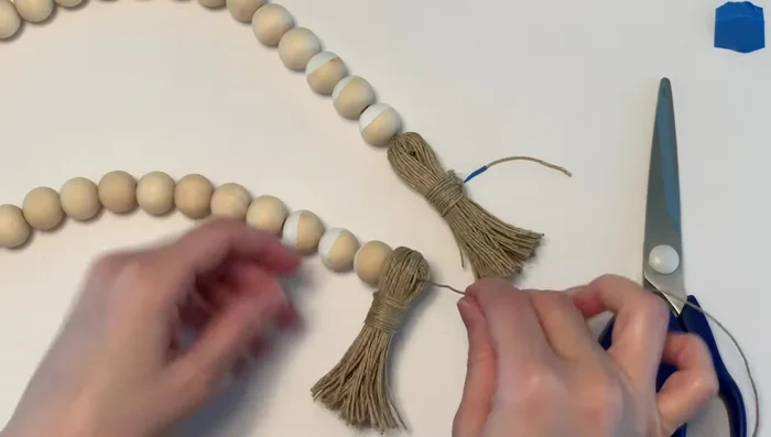 Attach second tassel: Attach the second tassel to the other end of the bead strand and double knot it tightly.