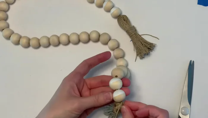 Finish and hide twine: Trim the extra twine, leaving about two to three inches. Tuck the remaining twine through several beads to hide it.