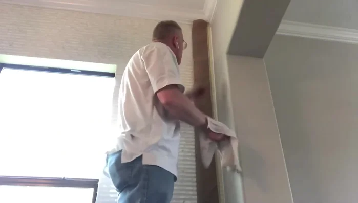 Wipe away excess caulking with a wet rag, maintaining a smooth surface.