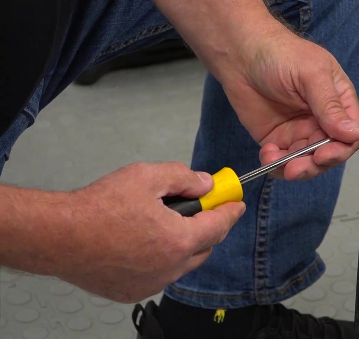Slide the new door stopper assembly into the opening, align the holes, and secure it with the Phillips screws.