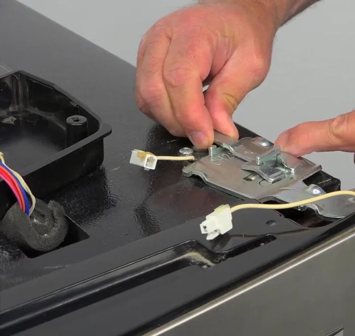 Install the hinge lock, plug in the door harness, and install the cover, ensuring the harness is inside the hinge.