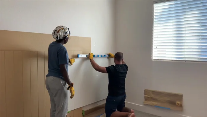 Install smooth vinyl panels on the first accent wall, spray painting them with Sache Sand for a cohesive look.