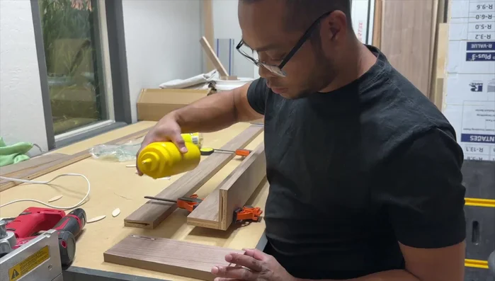 Build custom walnut bookshelves using biscuits, glue, and pin nails. Apply Rubio Monocoat and install under the window.