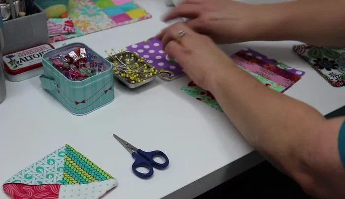 Select one fabric square as the base and set aside. Arrange the remaining four folded fabric triangles on top of the batting, overlapping corners to create a spinning pattern. Make sure the triangles are tucked under each other.