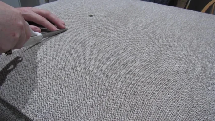 Carefully trim away the burned fabric, being mindful not to enlarge the hole.