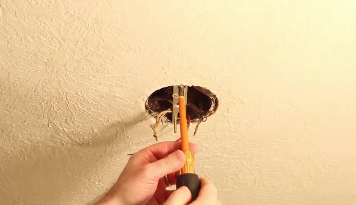 Use a voltage detector to check that the wires are not live before handling.