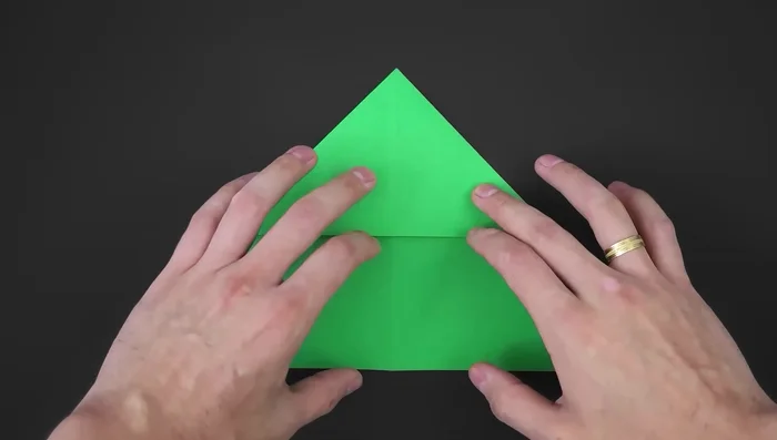 Fold creating two diagonals. Bring the right side to the middle, make a crease; repeat on the left side. Fold the paper along these two small diagonal lines.